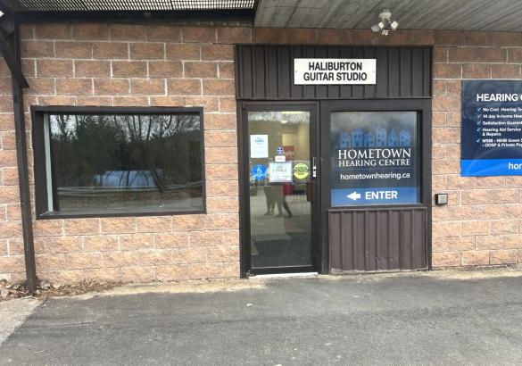 Brick front office space with window and glass door.